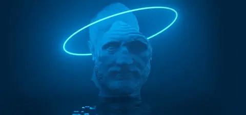 A large, illuminated sculpture of a stern male figure's head, partially submerged in water, with a glowing halo surrounding it, creating a mystical atmosphere.