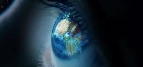 A close-up of an eye reflecting a vibrant image of Earth, surrounded by dark space, symbolizing perspective and global awareness.