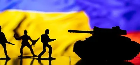Silhouettes of toy soldiers and a tank against a colorful background resembling a flag, suggesting themes of conflict or military action.
