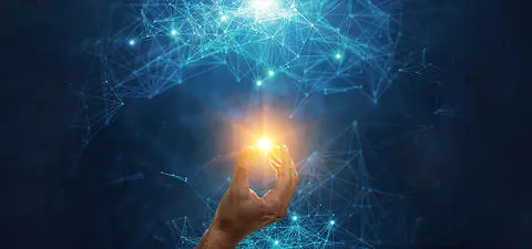 A hand reaches upwards, holding a glowing orb of light, surrounded by a network of interconnected blue lines and dots against a dark background.