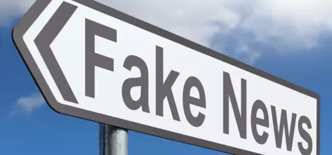 A street sign pointing left with the words 