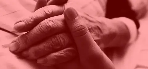 A close-up of two hands clasped together, one with visible signs of aging and the other younger, conveying a sense of connection and care.