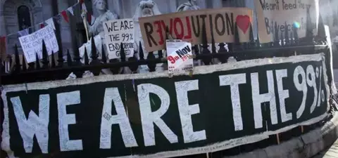 A protest scene with signs reading 