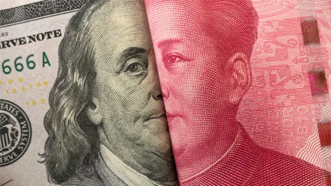 A close-up of a U.S. hundred-dollar bill featuring Benjamin Franklin partially overlapped with a Chinese hundred-yuan note depicting Mao Zedong.