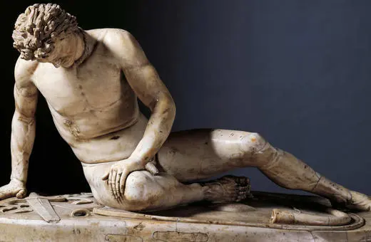 A marble statue of Heracles, depicted in a contemplative pose, sitting on the ground with one knee raised and hand resting on his leg.