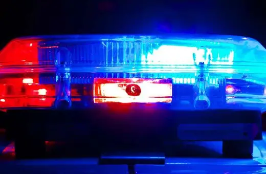 A close-up of a police car's light bar flashing red and blue lights, illuminating the surrounding area with a bright glow.
