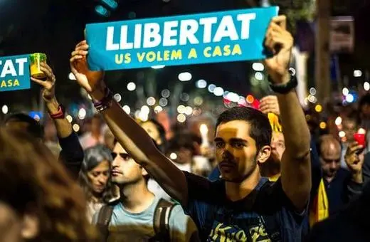 A young man holds a sign reading 