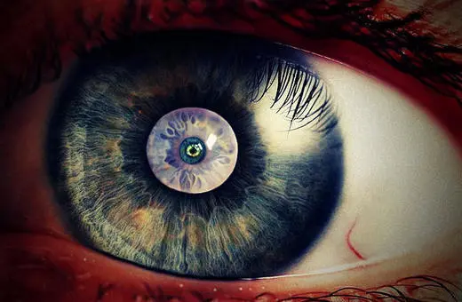 A close-up of a human eye, showcasing intricate patterns in the iris with shades of blue, green, and brown, highlighting the detailed textures and reflections.