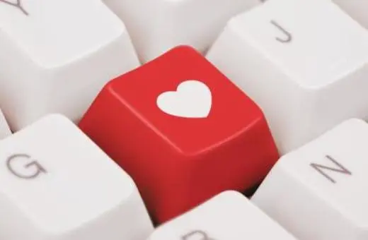 Red keyboard key featuring a white heart symbol, set against a white keyboard backdrop.