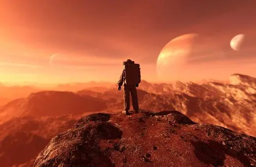 A solitary astronaut stands on a rocky outcrop, gazing at a vibrant extraterrestrial landscape with multiple planets in the sky and a glowing orange sunset.