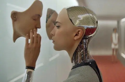 A humanoid robot with a metallic surface examines a removable mask while a woman in the background observes, highlighting themes of identity and artificial intelligence.